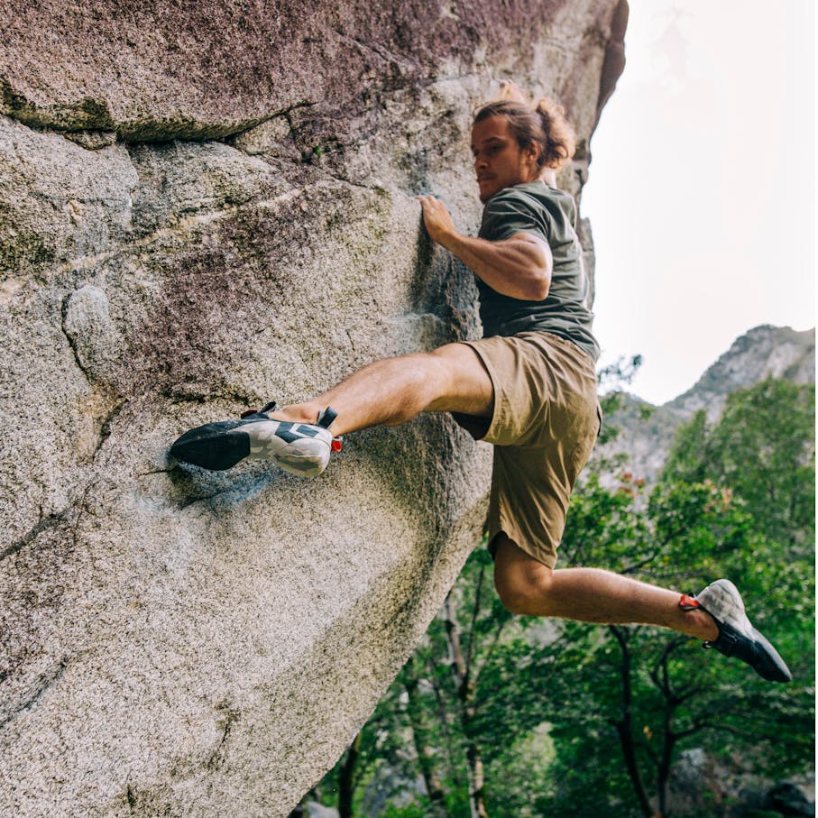A boulderer sticks his foot out on a climb.