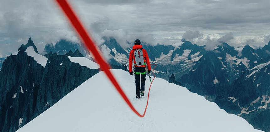 Das Bild eines Bergsteigers auf einem verschneiten Bergrücken 