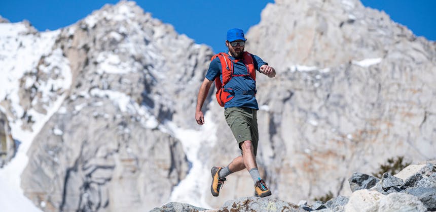 A hiker scrambles across some talus in the Mission approach shoes. 