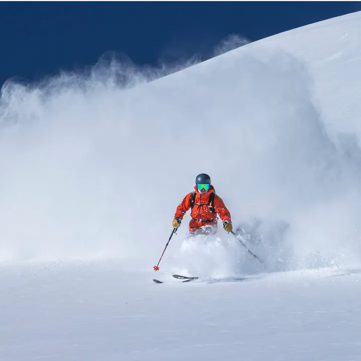 A skier emerges from a cloud of cold smoke in a Recon Shell. 