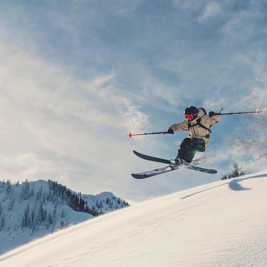 A backcountry skier catches some air wearing the Recon Stretch Pro Shell.
