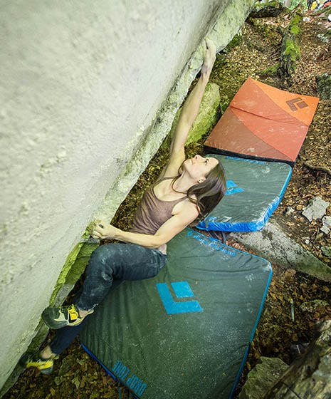 Photo of Kaddi Lehmann bouldering above Black Diamond crash pads.
