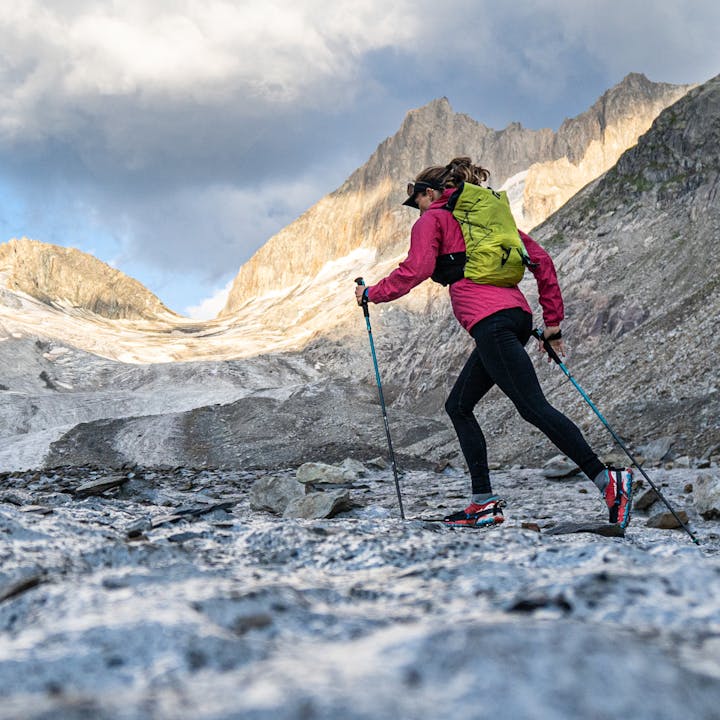 A runner wears a Black Diamond Distance Running Pack and jogs across a glacier. 