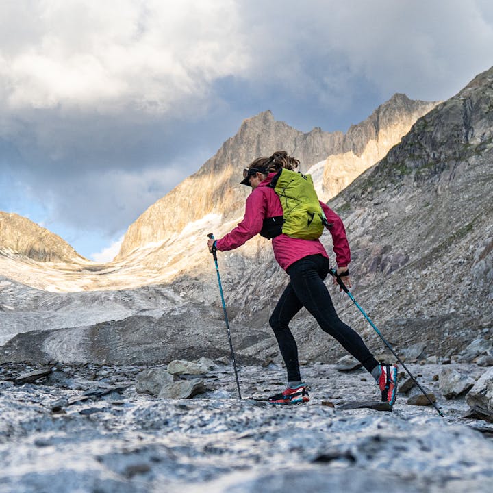 A runner wears a Black Diamond Distance Running Pack and jogs across a glacier. 