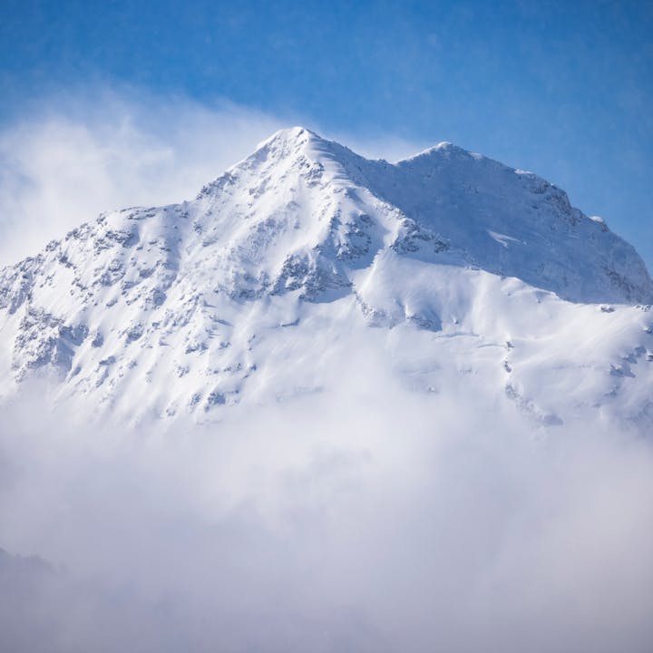 A landscape image of a snow covered mountain. 