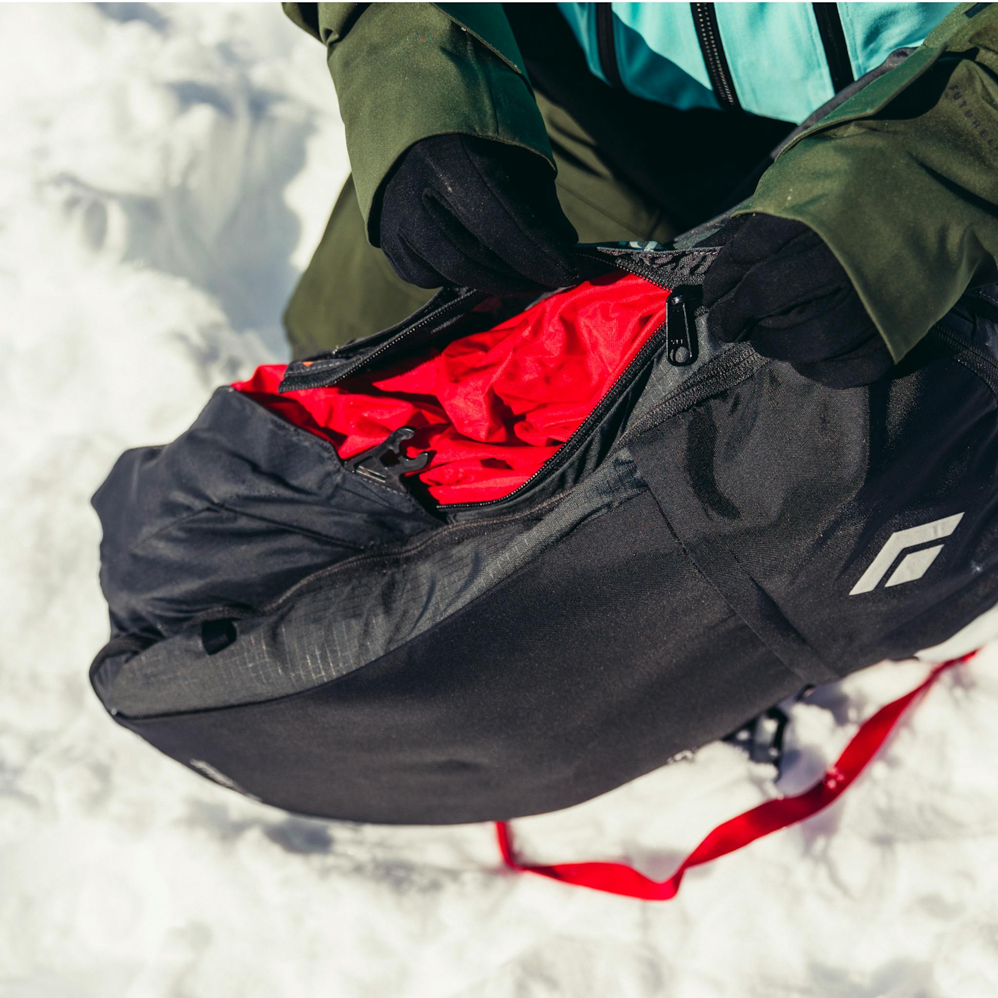 Ein Skifahrer packt den Jetforce-Airbag zurück in den Rucksack.