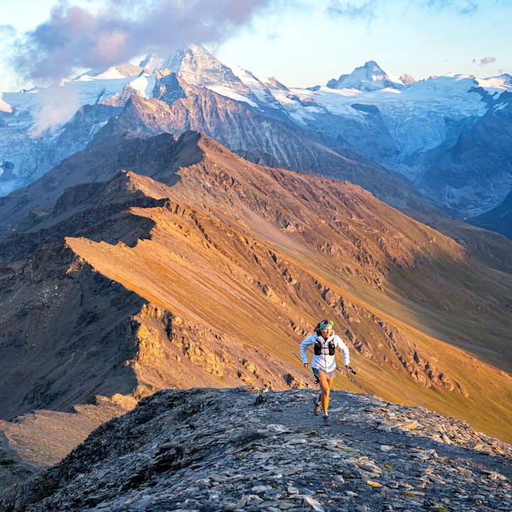 A runner on a ridge, beautiful mountains behind them. 