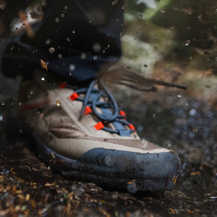 A Mission LT 2.0 Approach shoe kicks up mud and water. 