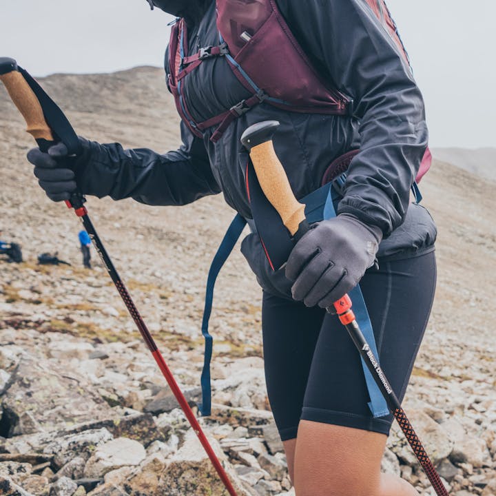 A hiker treks up a cold mountain with Black Diamond Poles.
