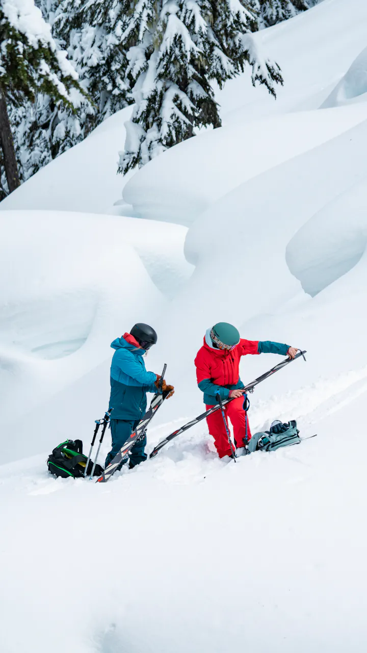 Two Backcountry Skiers apply their climbing skins to their Black Diamond Skis. 