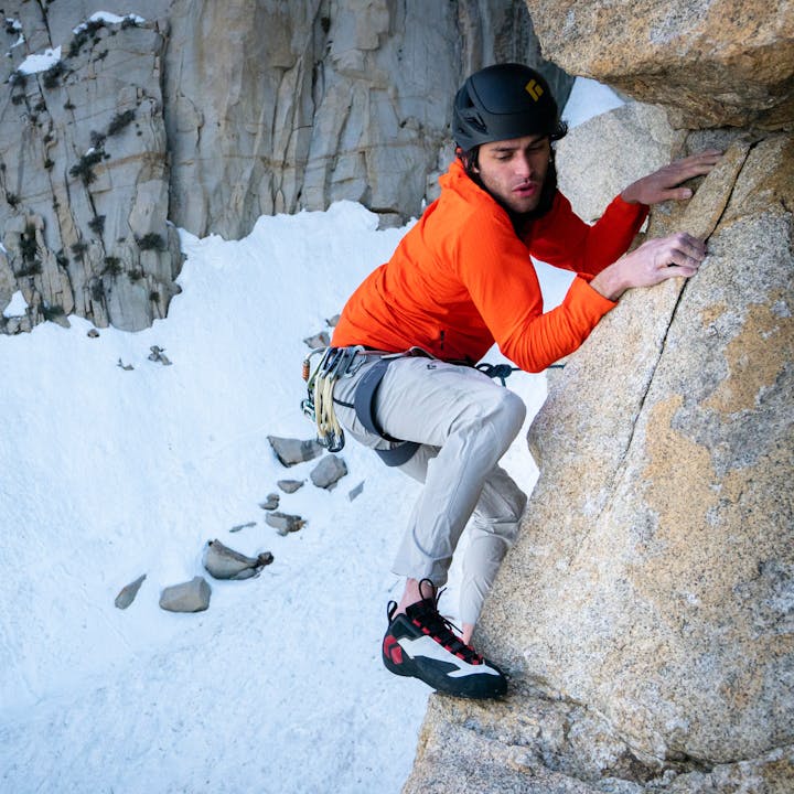 A alpine climber wearing the alpine light climbing pants. 