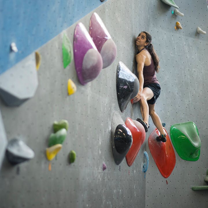 BD athlete Fanny Gibert climber balancing on two holds works her way up the slap problem. 