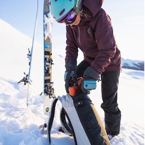 Skier rips skins and gets ready to descend in their Black Diamond Dawn Patrol Hoody.  