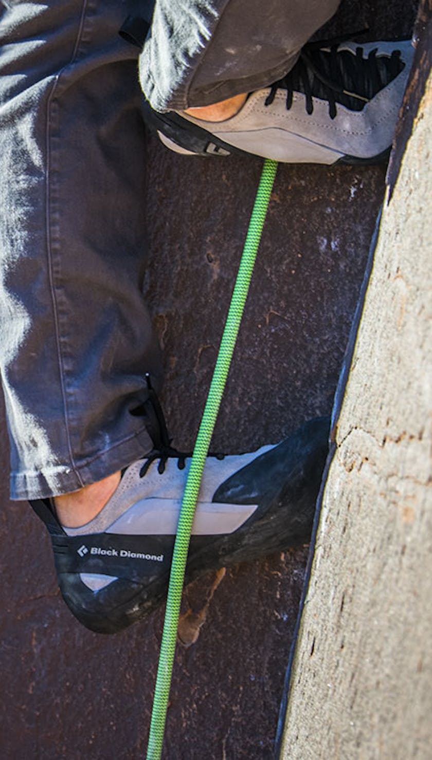 man working up a crack in Black Diamond climbing shoes