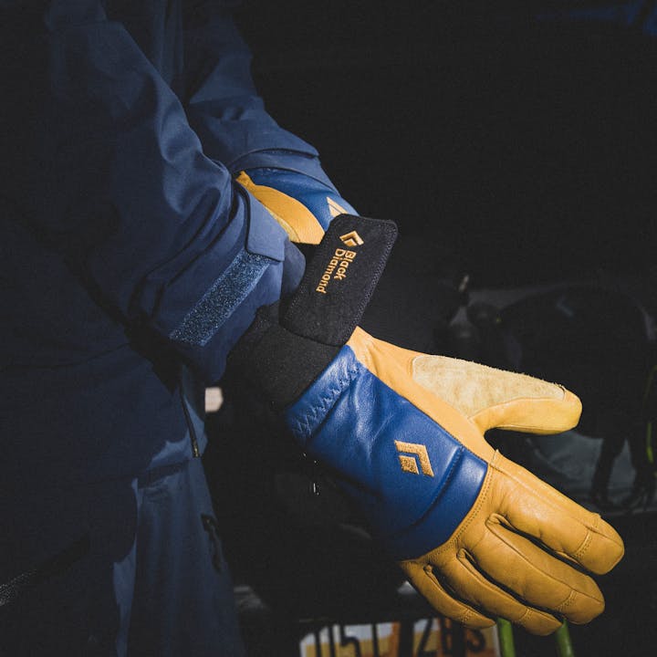 A ski tourer puts on a pair of Black Diamond Spark Mitts in the early morning. 