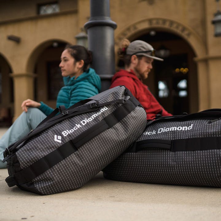 Foto: Christian Adam, zwei Leute, die mit den Black Diamond Duffel Bags auf den Zug warten.