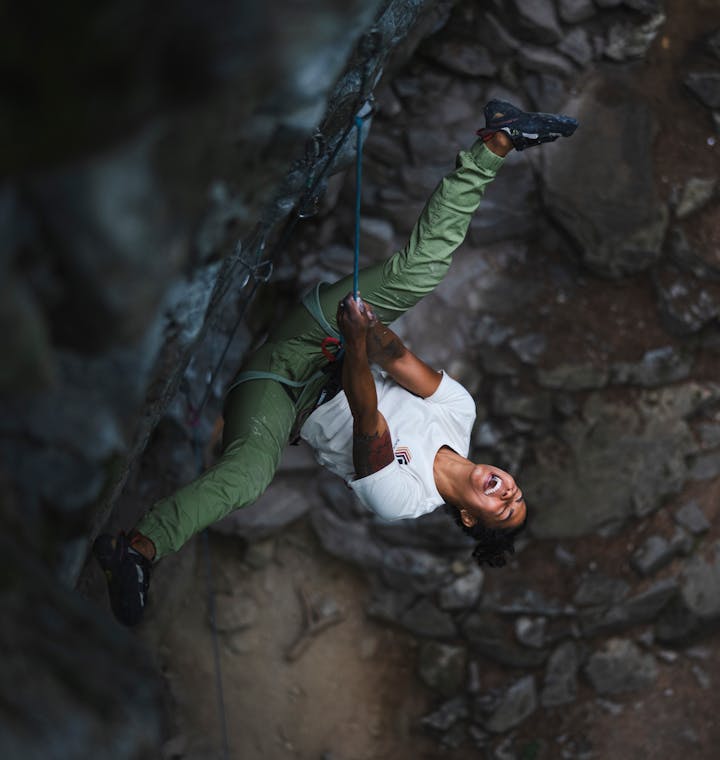 Women's Climbing Clothing. A climber sings around after falling off of a climb. 