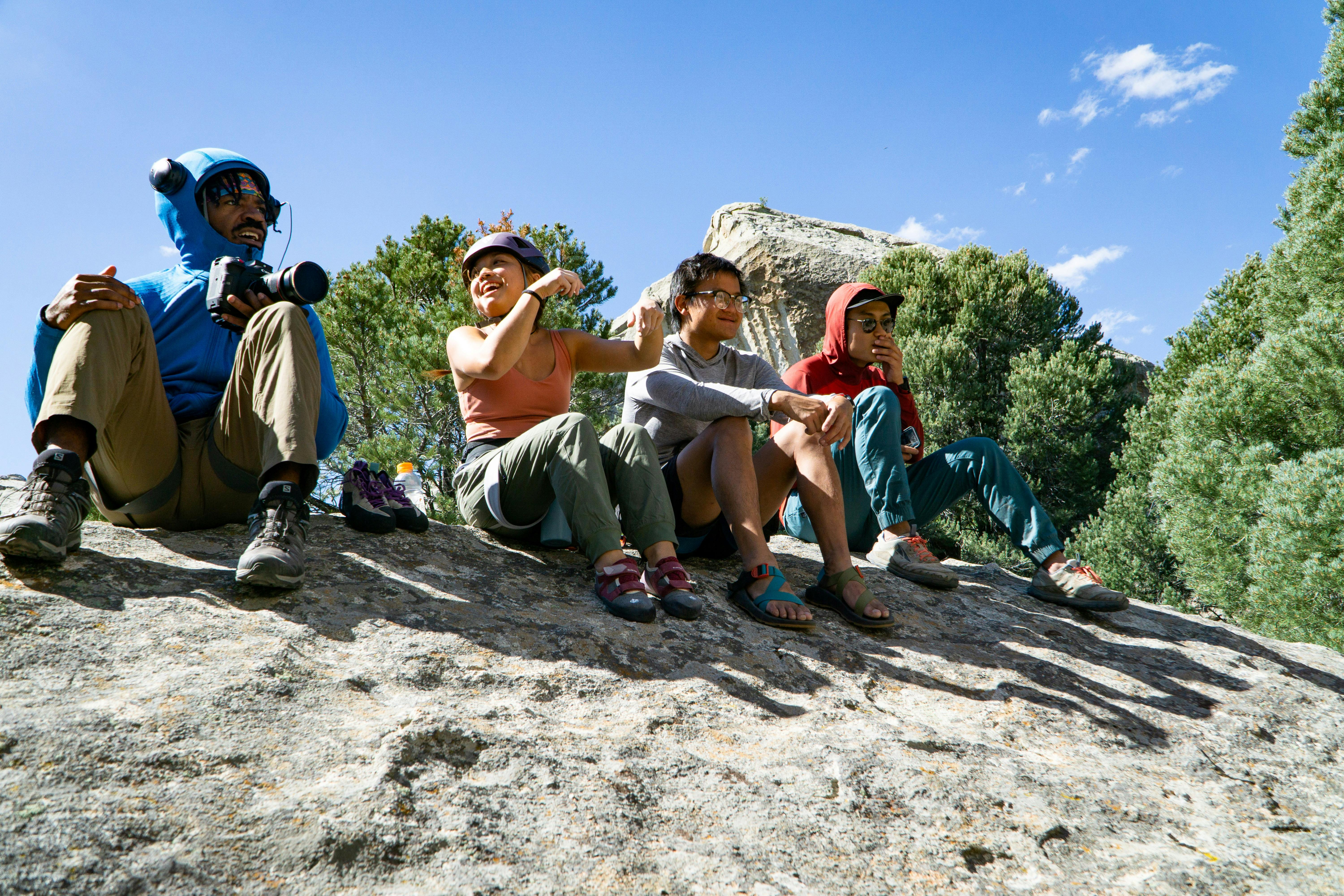 Climbers sit on a rock.