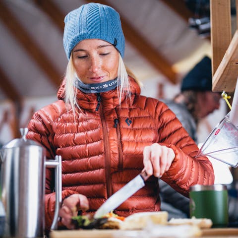 A backcountry Skier cooks breakfast in a yurt. 