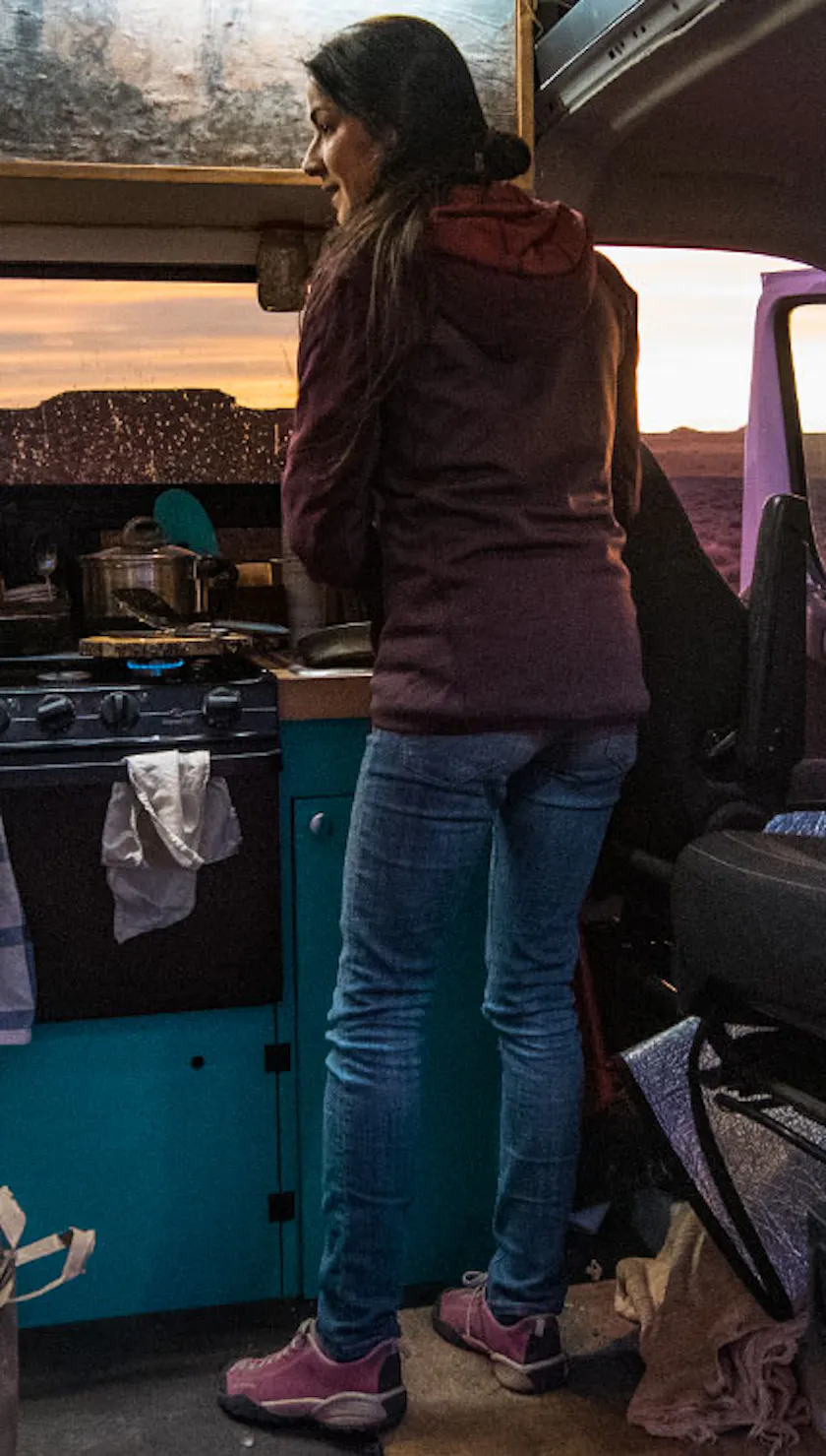 woman making dinner in her campervan