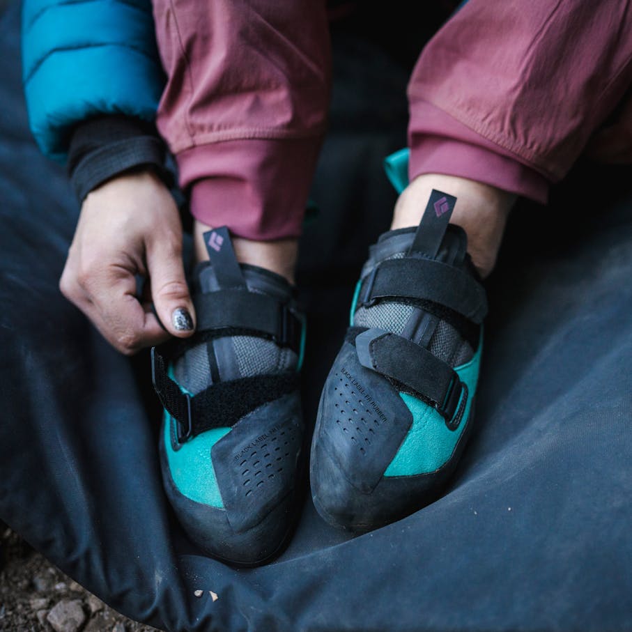 A climber cinches the velcro straps on her Method Climbing Shoes.