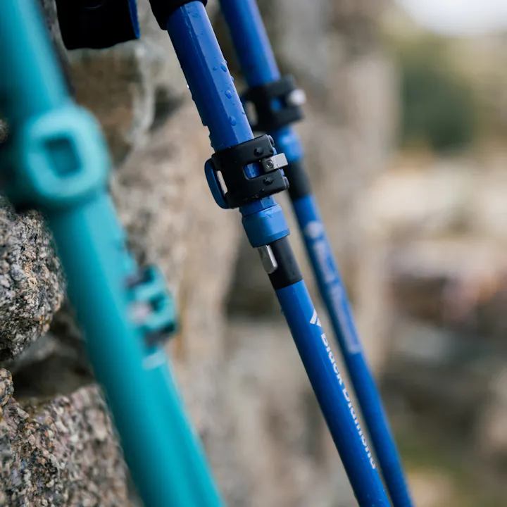 Two pair of Black Diamond Distance Trekking poles rest against a wall. 