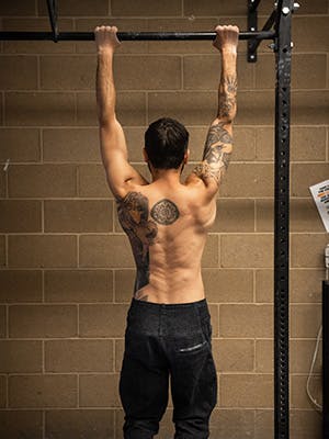 Photo of Sam Elias hanging from a pull up bar.