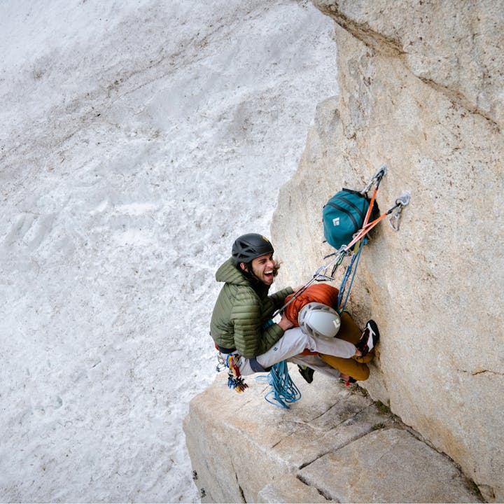 Two climbers enjoy a laugh on a nice belay ledge.