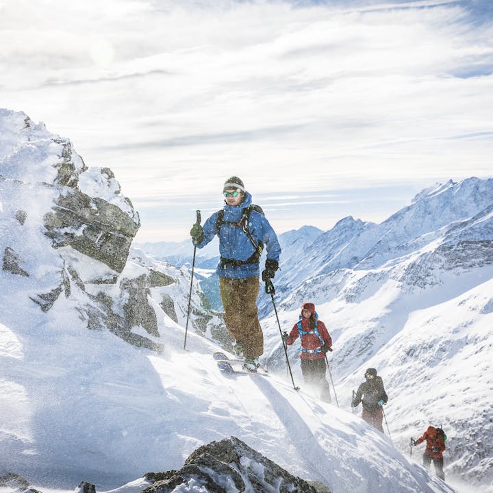 skiers hiking up a ridge