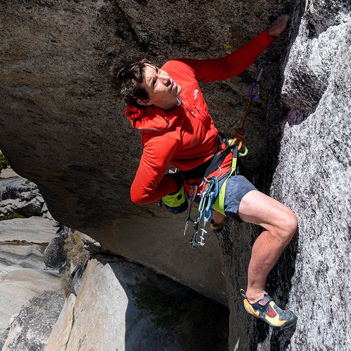 Alex Honnold reaching to place a piece of rock protection