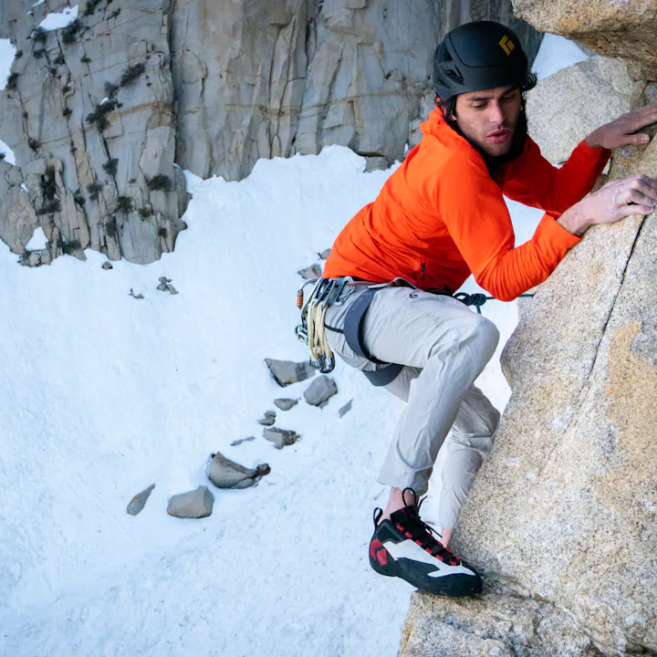 A climber moves across a face in Black Diamond Alpine Pants. 