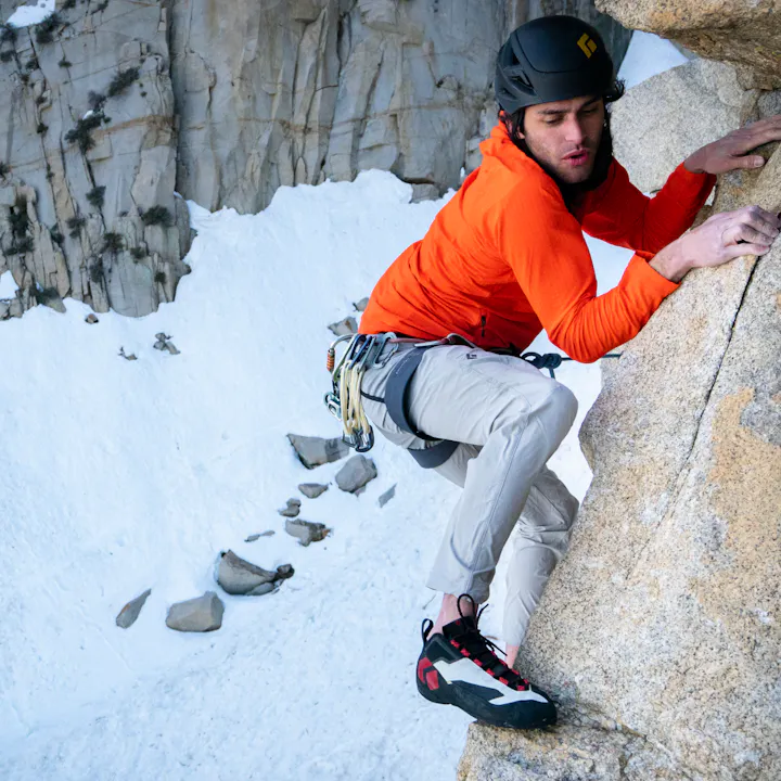 A climber moves across a face in Black Diamond Alpine Pants. 
