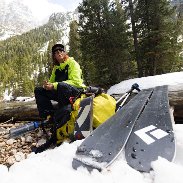 A skier takes a break after skiing a line in Spring.