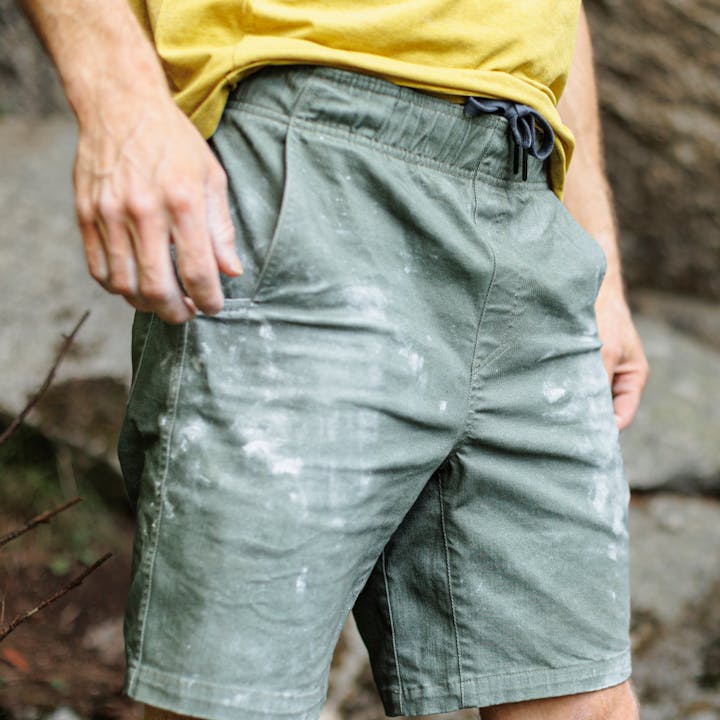A climber takes a break after a boulder his Dirtbag Shorts covered in chalk. 