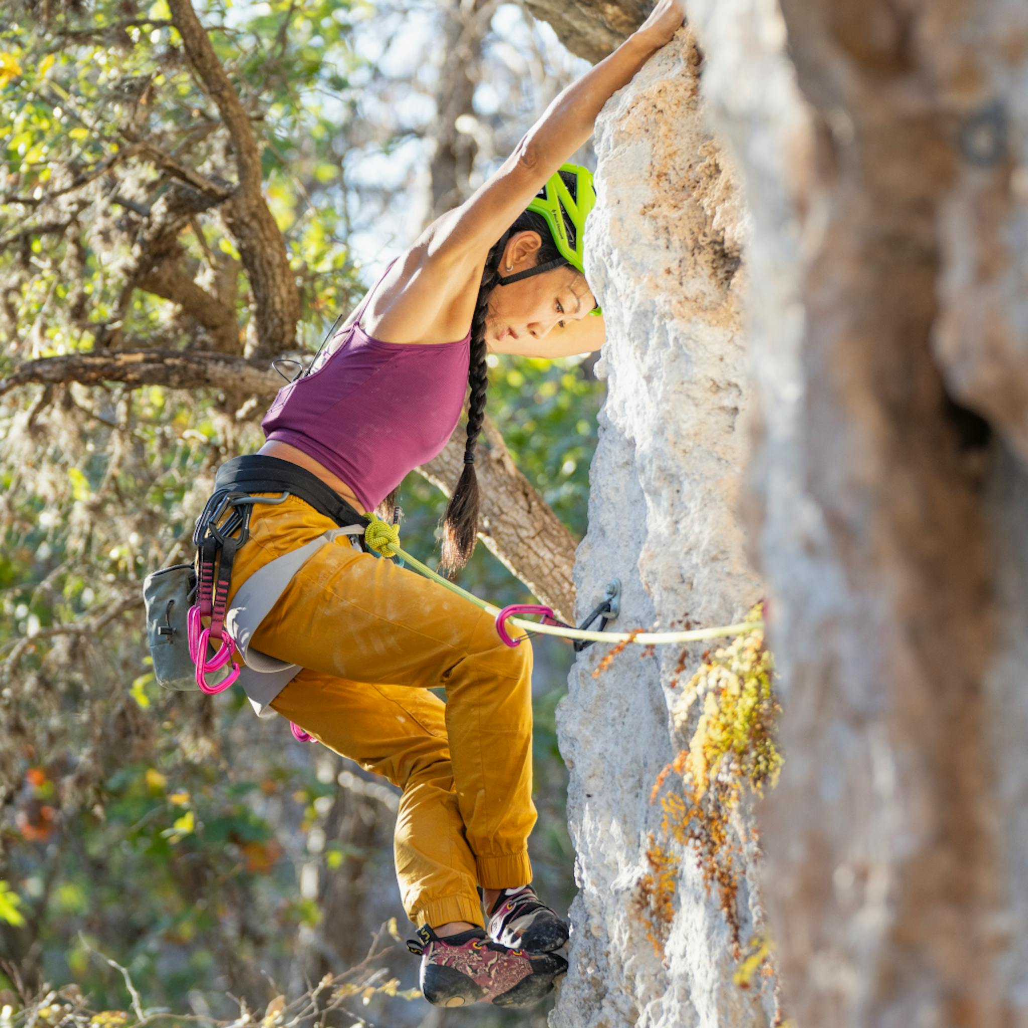 A climber readjust her feet on a sport climb.