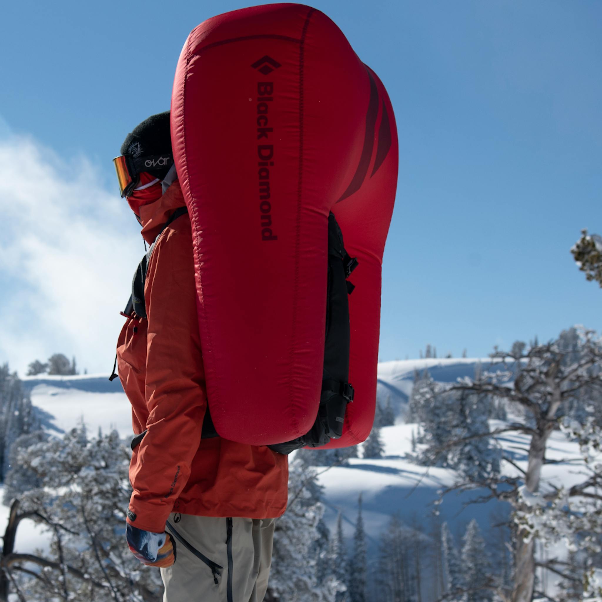 Ein Snowboarder steht mit einem ausgelösten Jetforce-Rucksack vor der Kamera.